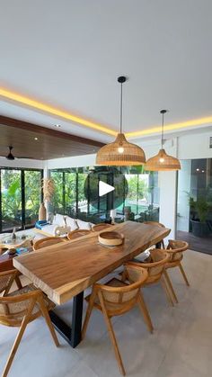 a large wooden table sitting in the middle of a living room with lots of windows