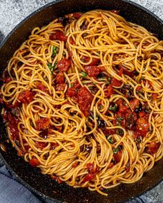 a pan filled with spaghetti and sauce on top of a table