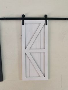 an open barn door hanging on a wall next to a black and white tie bar