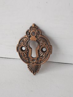 an antique style door handle on a white painted wooden surface with a keyhole in the center