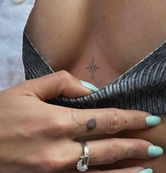 a woman's hand with a cross tattoo on her left side and a diamond ring