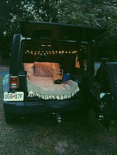 an open bed in the back of a pick up truck with lights strung over it