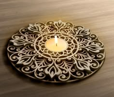 a lit candle sits in the middle of a circular design on a table top ornament