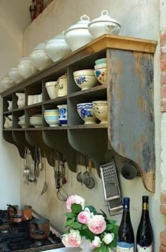 an old kitchen with pots and pans hanging on the wall above the stove top