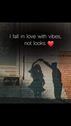 two people standing next to each other in front of a brick wall with the words i fall in love with vibes, not looks