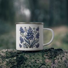 a blue and white coffee cup sitting on top of a tree stump