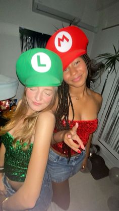 two young women dressed up in mario and luigi's hats, posing for the camera