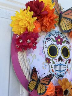 a wreath decorated with flowers and butterflies on the front door to celebrate day of the dead