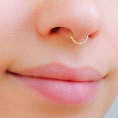 a woman's nose with a gold nose ring