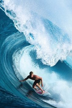 a man riding a wave on top of a surfboard in front of a blue ocean