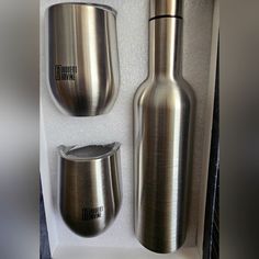 two stainless steel cups and a bottle in a box