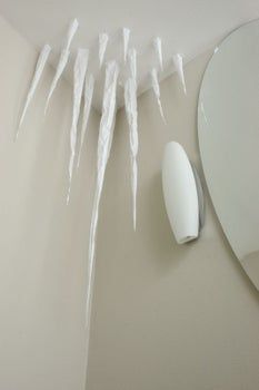 icicles hang from the ceiling next to a mirror with a hair dryer on it