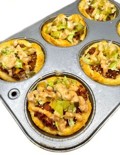 a muffin tin filled with mini pizzas covered in toppings