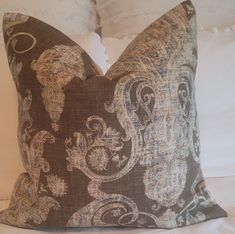 a decorative pillow on top of a white bed