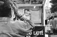 a woman standing in front of a food cart talking on her cell phone