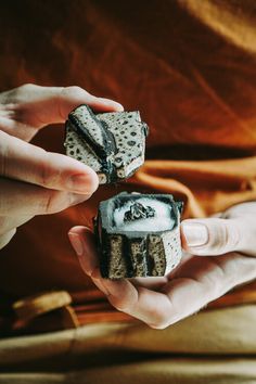 two hands holding small pieces of food in each hand