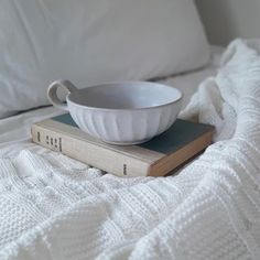 a white bowl sitting on top of a stack of books