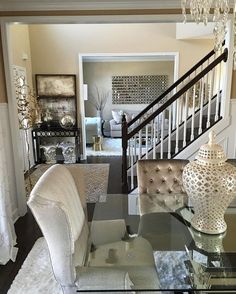 a living room filled with furniture next to a stair case in a home's entryway