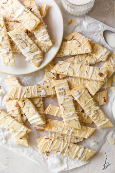 white chocolate and almond shortbreads on parchment paper next to a glass of milk