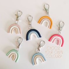 six rainbow shaped key chains with the words choose your own colors on them in white, blue, green, yellow, pink, orange and purple