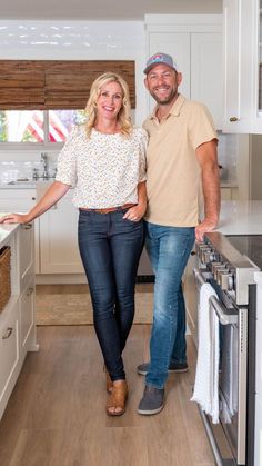 a man and woman standing next to each other in a kitchen