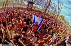 a crowd of people standing around each other at a music festival