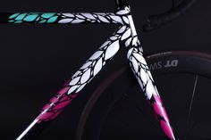 a close up of a bike with pink and white designs on it's front wheel