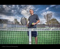 a man standing on a tennis court holding a racquet and ball in his hands