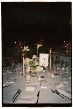 the table is set with candles, flowers and napkins for an elegant wedding reception