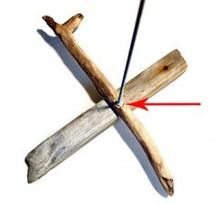 a cross made out of wooden sticks with one red arrow pointing to the other side