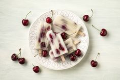 some ice cream and cherries on a white plate