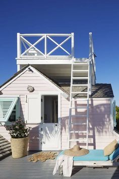 a pink house with a ladder to the roof