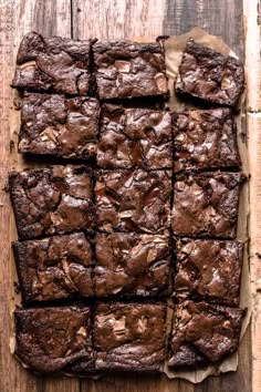 chocolate brownies cut into squares on top of a wooden table