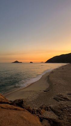 the sun is setting over the ocean and beach