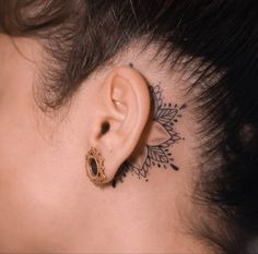 a woman's ear has a tattoo on it