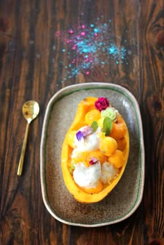 a plate with some food on it and a spoon next to it, sitting on a wooden table