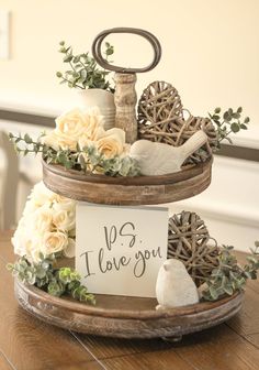 a three tiered tray with flowers and an i love you sign