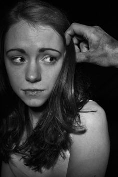 a black and white photo of a woman getting her hair combed