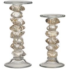 two glass candlesticks sitting next to each other