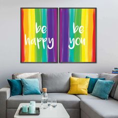 two canvases with the words be happy you on them in front of a couch