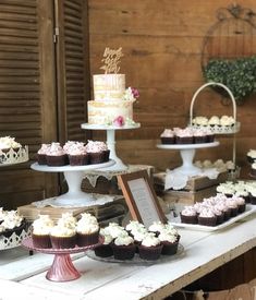 a table topped with lots of cupcakes on top of cakes and pies