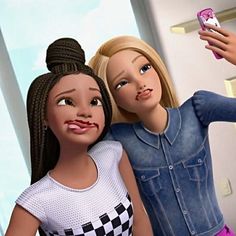 two dolls are standing next to each other and one is taking a selfie with her cell phone