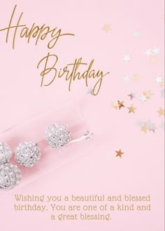 a birthday card with three silver balls and stars in the background on a pink background