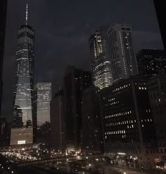 the city skyline is lit up at night with skyscrapers in the foreground and cars on the street below