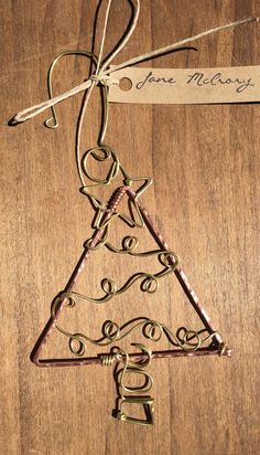 a metal christmas tree ornament hanging on a wooden table