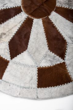 a brown and white cowhide rug on top of a table with an animal skin pattern