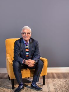 an older man sitting in a yellow chair