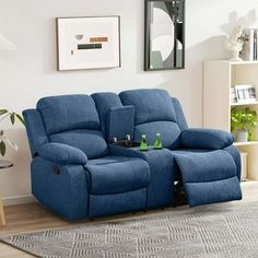 a blue reclining loveseat sitting in a living room next to a rug