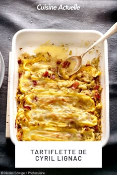 a casserole dish with meat and cheese in it on a black tablecloth