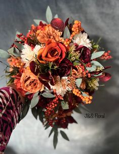 a bridal bouquet with orange and red flowers